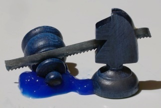 Chess knight sawing a pawn, with blue ketchup